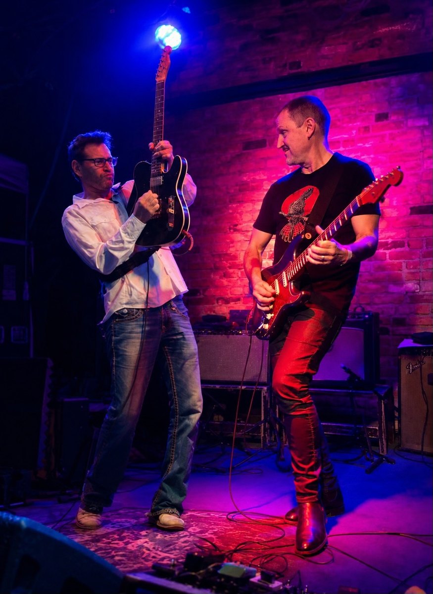 Ben Butler and Sam Hawksley playing guitar on stage